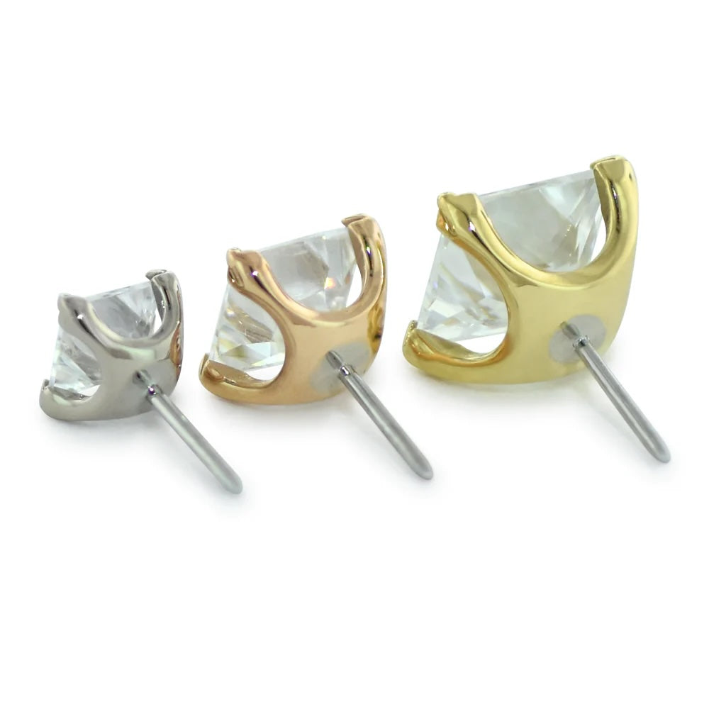 Pair of crystal stud earrings in gold and silver on a white background