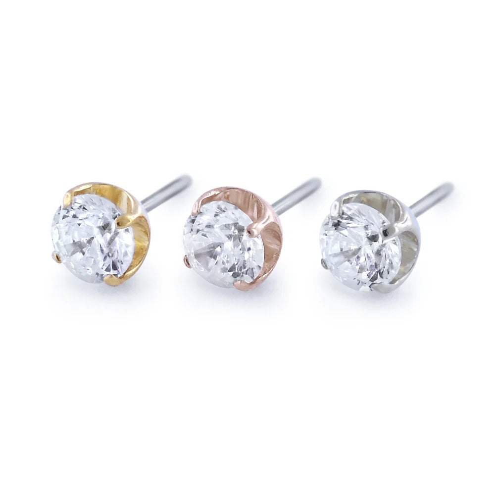 Three diamond stud earrings in gold, rose gold, and silver on a white background