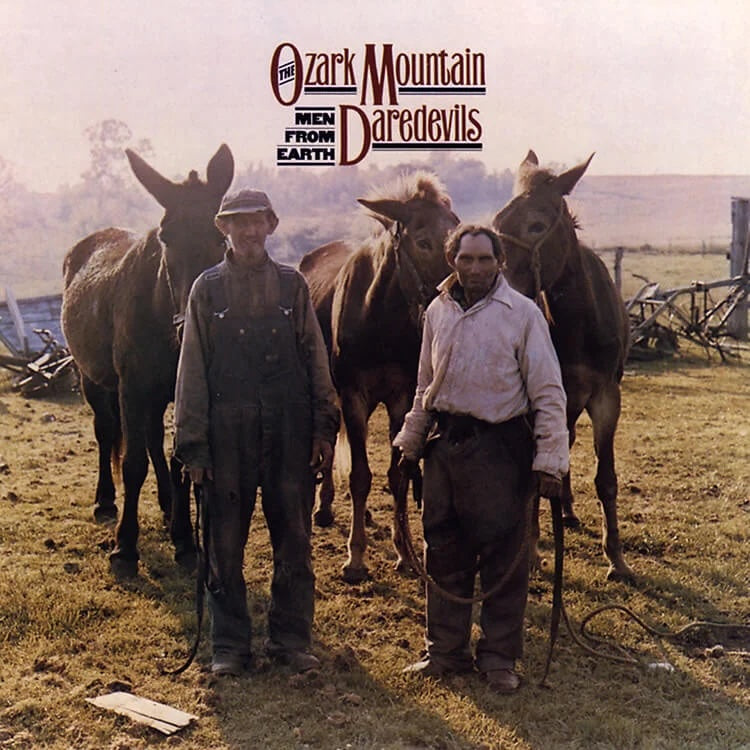 Two men standing with horses in a field, featuring 'The Ozark Mountain Men from Earth Daredevils' text.