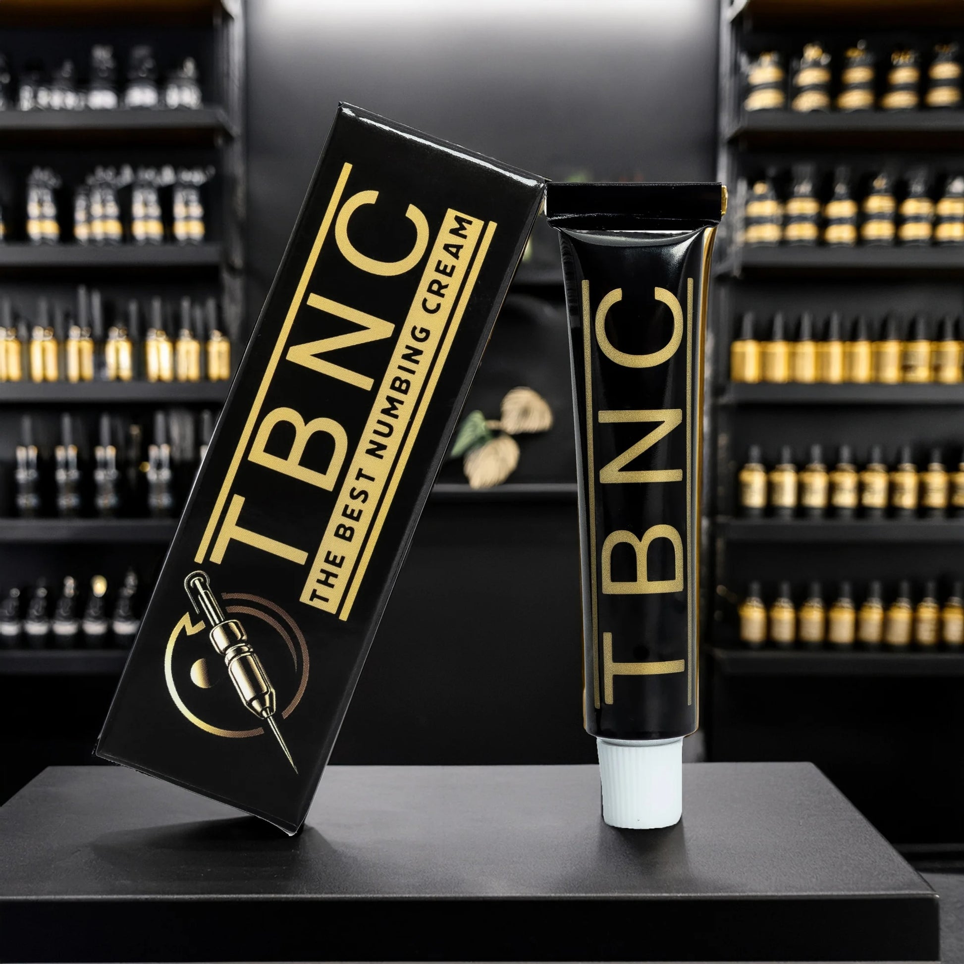 TBNC numbing cream packaging on a black surface with shelves in the background